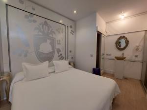 a white bed with white pillows in a room at La Princesa y El Guisante in Conil de la Frontera