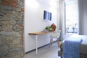 um quarto com uma mesa num quarto com uma parede de tijolos em Il Bordone - affittacamere a Manarola, Cinque Terre em Manarola