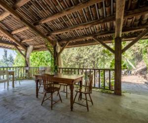 a wooden table and chairs on a covered porch at Il mestiere di vivere -casa vacanze- in Santo Stefano Belbo