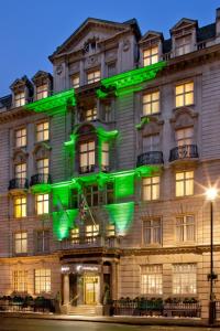 ロンドンにあるホリデイ イン ロンドン オックスフォード サーカスの緑の灯る大きな建物