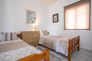 a bedroom with two beds and a dresser and a window at FALIRAKI CITRUS GARDEn in Faliraki
