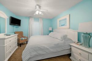 een blauwe slaapkamer met een bed en een plafondventilator bij Pelican Beach 0805 by Pelican Beach Management in Destin
