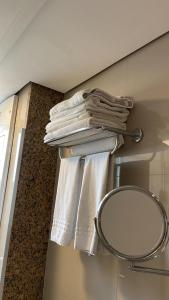 einen Handtuchhalter mit Handtüchern und einem Spiegel im Bad in der Unterkunft Flat Particular Hotel Lets Idea - SEM CAFÉ in Brasilia