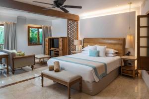 a bedroom with a large bed and a living room at Valentin Imperial Riviera Maya All Inclusive - Adults Only in Puerto Morelos