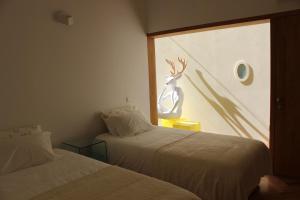 two beds in a room with a deer on the window at Groove-Wood Loft in Vila Nova de Gaia