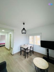Una sala de estar con una mesa y un piano. en Apartamento Peñon de Ifach, en Calpe