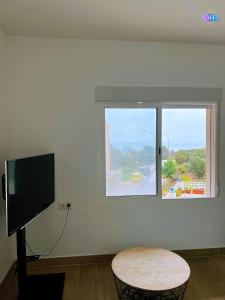 um quarto com uma televisão, uma mesa e uma janela em Apartamento Peñon de Ifach em Calpe