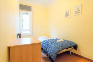 1 dormitorio con cama, escritorio y ventana en Pintor Pahissa Rooms, en Barcelona