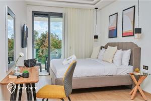 Stayhere Rabat - Hay Riad - Sophisticated Residence في الرباط: غرفة نوم بسرير وطاولة وكرسي