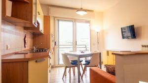 une cuisine avec une table et des chaises ainsi qu'une fenêtre dans l'établissement Caprice Appartamenti Vacanze, à Diano Marina