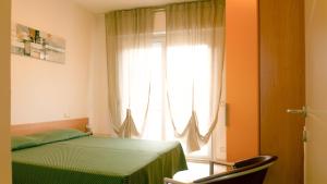 - une chambre avec un lit vert et une fenêtre dans l'établissement Caprice Appartamenti Vacanze, à Diano Marina