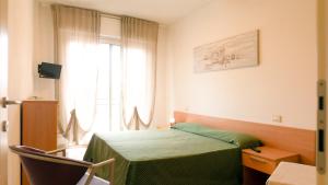 a bedroom with a green bed and a window at Caprice Appartamenti Vacanze in Diano Marina