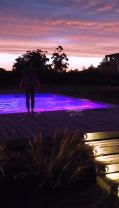 a person walking on a boardwalk with purple lights at Hjem Studios in La Pedrera