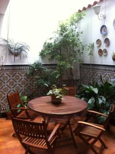 een houten tafel en stoelen in een kamer met planten bij Hostal Senero in Merida