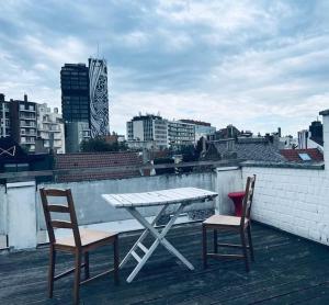 una mesa y dos sillas sentadas en el techo en Ravissant appartement Louisa, en Bruselas