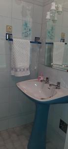 y baño con lavabo blanco y espejo. en Apartamento Abril, en Gouveia