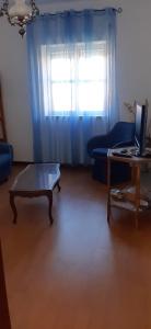 uma sala de estar com um sofá azul e uma mesa em Apartamento Abril em Gouveia