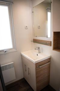 a bathroom with a sink and a mirror and a window at amorosa mobil home in Canet-en-Roussillon