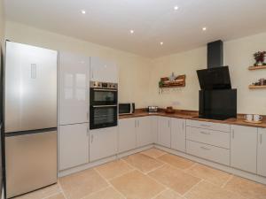 a white kitchen with white cabinets and appliances at The Hame in Monmouth