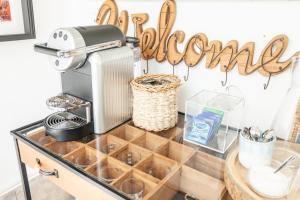 a kitchen counter with a coffee maker and a sign that readsuador at Blue Buddha Beach Rooms & Suites in Ericeira