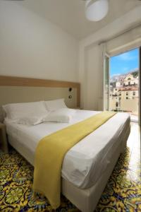 a bedroom with a large bed with a large window at Hotel Torre Di Milo in Maiori