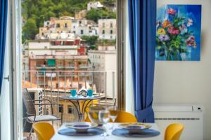 a balcony with tables and chairs and a view of a city at CASA DONNA LINDA in Maiori