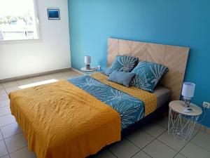 sypialnia z łóżkiem z niebieską ścianą w obiekcie Casa Maya quartier des pêcheurs terre sainte avec garage box w mieście Saint-Pierre