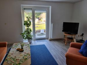 ein Wohnzimmer mit einem Sofa und einem TV in der Unterkunft Ferienwohnung Schorfheide Krüger in Joachimsthal