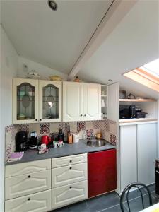 uma cozinha com armários brancos e um lavatório em Studio Mer & Aa-terrasse-jardin-WIFI-parking-classé 3 étoiles em Grand-Fort-Philippe