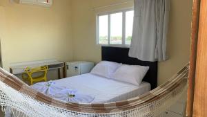 een bed in een hangmat in een kamer met een raam bij Floripa Flat in Areia Branca