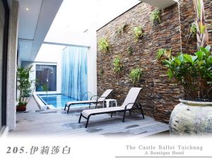 patio z krzesłami i ceglaną ścianą w obiekcie The Castle Ballet Taichung A Boutique Hotel w mieście Taizhong