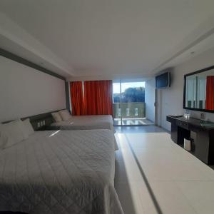 a hotel room with two beds and a large window at Hotel Borda Cuernavaca in Cuernavaca