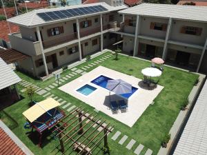 - une vue aérienne sur une maison avec une piscine et un parasol dans l'établissement Pousada das Bandeiras, à Olímpia