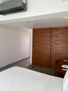 1 dormitorio con cama y armario de madera en Hotel Plaza Kokai Cancún en Cancún