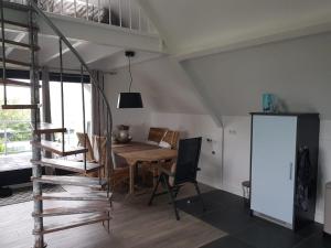 a dining room with a wooden table and a loft at Prins van Poederoijen in Poederoijen