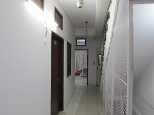 a hallway of a hospital with white walls and a door at Ashish Guest House, Udaipole in Udaipur