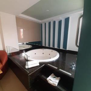 a bathroom with a large tub on a black counter at Hotel Borda Cuernavaca in Cuernavaca