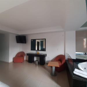 a bathroom with two red chairs and a sink at Hotel Borda Cuernavaca in Cuernavaca