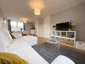 a living room with a white couch and a tv at Scandi Style Duplex Sleeps 6 in Linlithgow