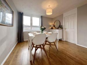 een eetkamer met een witte tafel en stoelen bij Scandi Style Duplex Sleeps 6 in Linlithgow