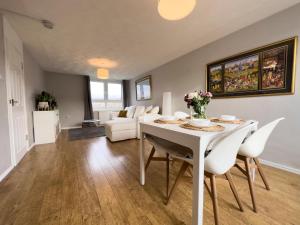 Scandi Style Duplex Sleeps 6 في لينليثغو: غرفة معيشة مع طاولة وكراسي بيضاء