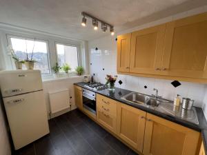 cocina con nevera blanca y fregadero en Scandi Style Duplex Sleeps 6, en Linlithgow