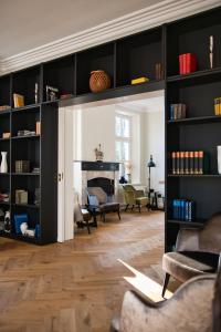 a living room with black shelves and a fireplace at Landhaus Gut Halte in Papenburg