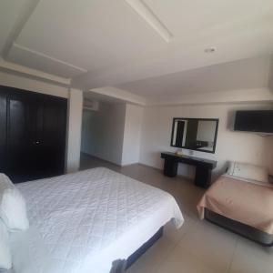 1 dormitorio con 1 cama y TV de pantalla plana en Hotel Borda Cuernavaca, en Cuernavaca