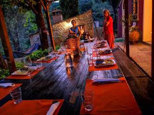 długi drewniany stół z talerzami żywności w obiekcie Piccola casa toscana con giardino con vista mozzafiato w mieście Podere Cordicella