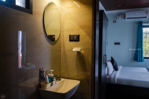 W łazience znajduje się umywalka i lustro. w obiekcie Reunion Ocean Tides w mieście Udupi