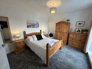 sypialnia z łóżkiem i 2 drewnianymi komodami w obiekcie Light And Spacious Highcross Apartment w mieście Poulton le Fylde