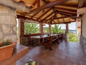 an outdoor patio with a long table and benches at Apartments Juric in Rab