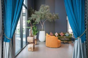 Best Western Chatuchak في بانكوك: غرفة معيشة مع ستائر زرقاء وأريكة