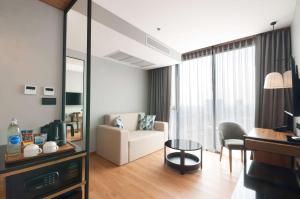 a living room with a couch and a chair and a mirror at Best Western Chatuchak in Bangkok +89 photos